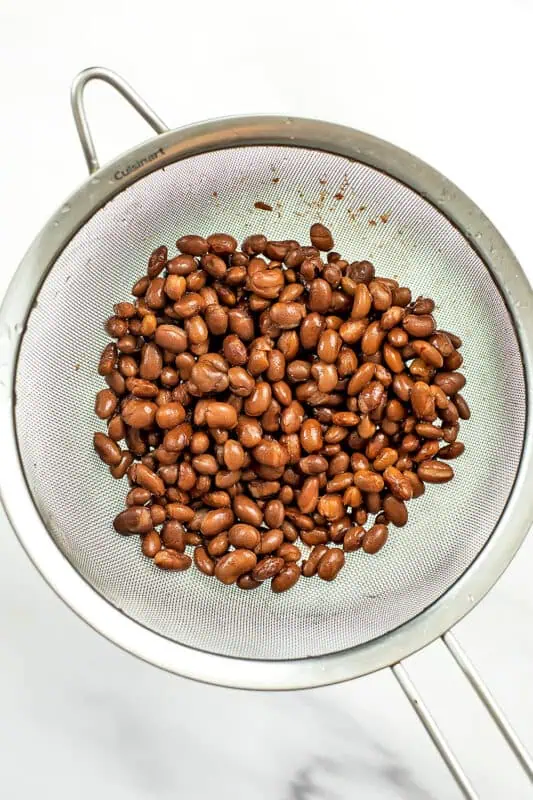 Black beans in a mesh strainer.
