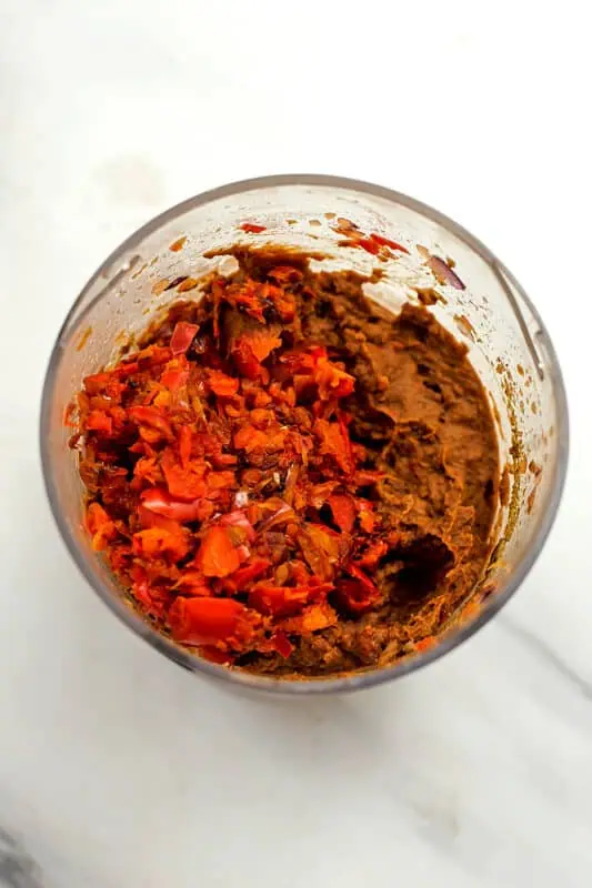 Veggies added to food processor with mashed black beans.