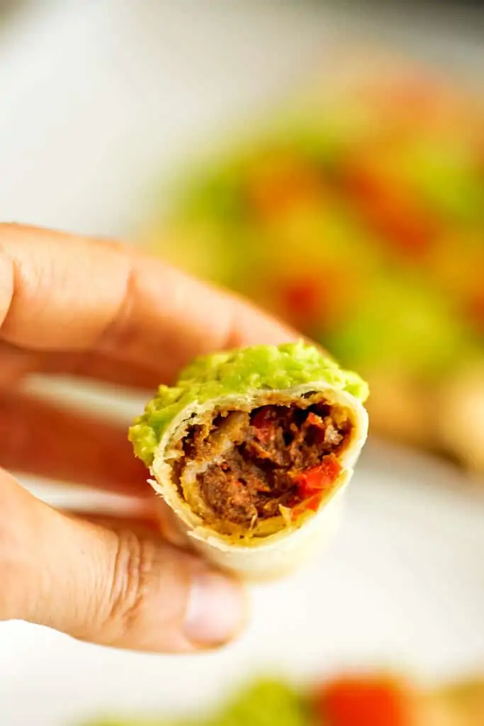 Center of a vegan taquito being held by a hand.