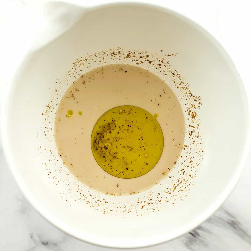 Wet ingredients for the corn bread in a large white bowl.