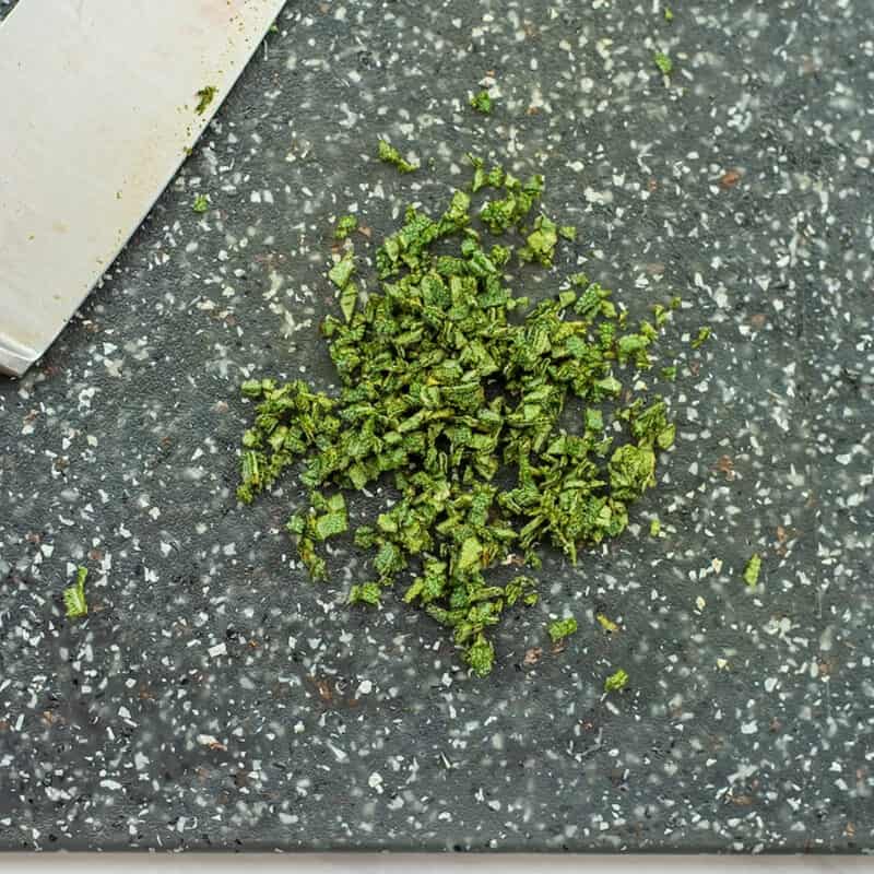 Chopped sage on a cutting board.