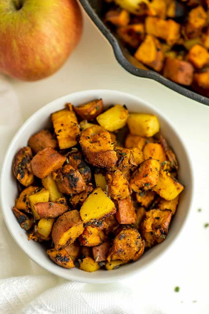 White bowl filled with sweet potato apple hash.