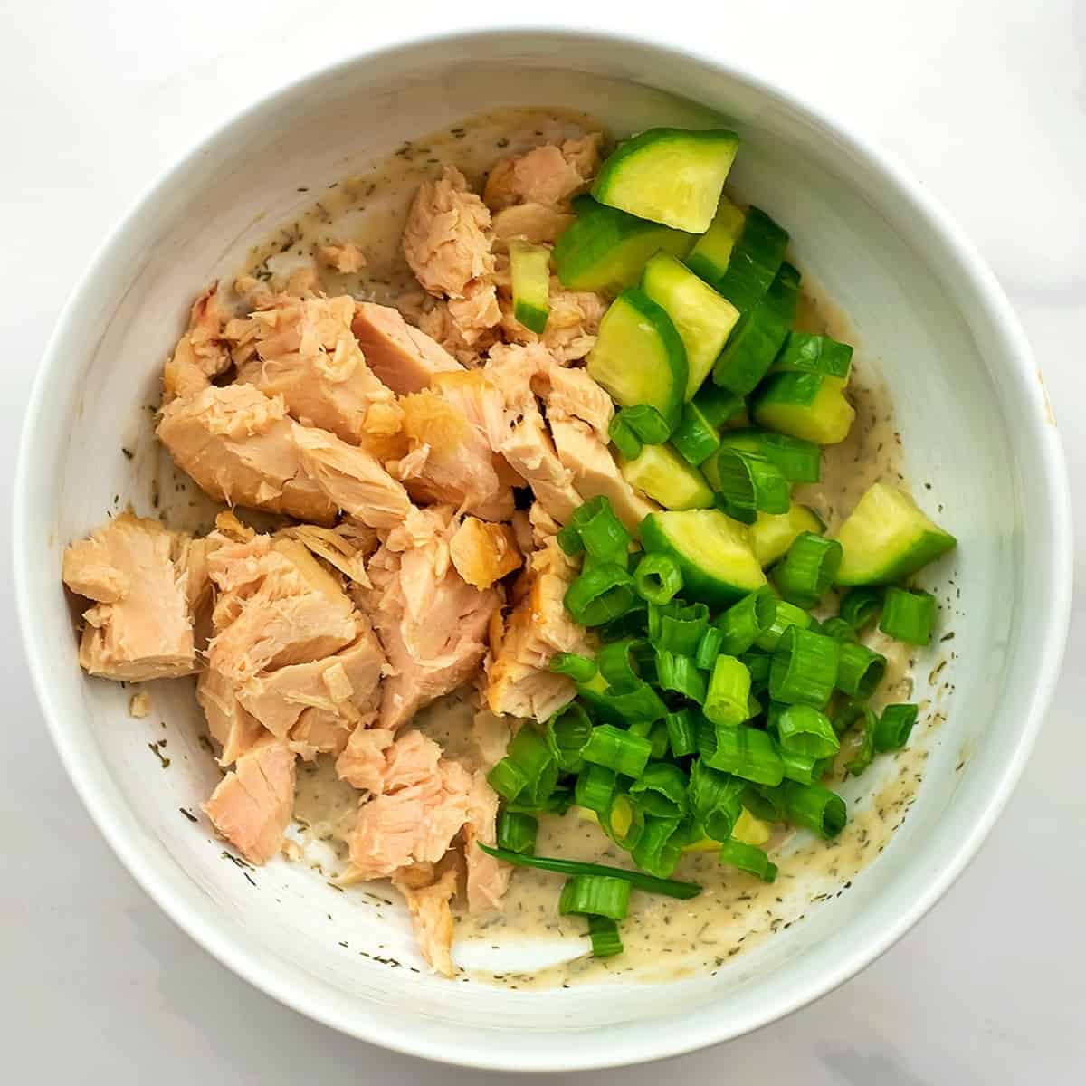 Tuna and veggies in the bowl with the dressing.