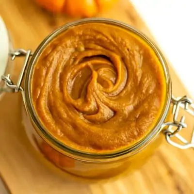 Maple pumpkin butter in a glass jar with silver hinges.