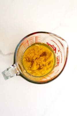 Ingredients to make maple tahini dressing in a glass measuring cup.