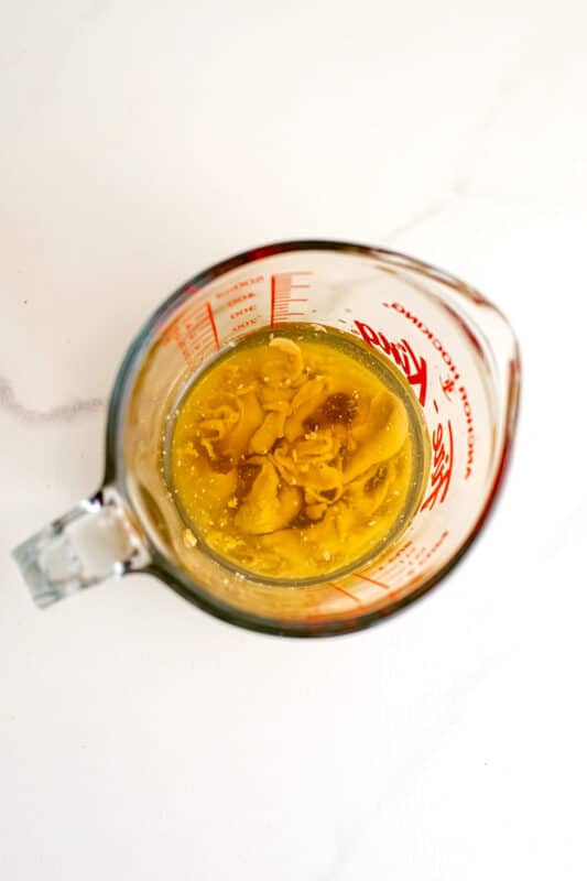 Ingredients for maple tahini dressing in a measuring cup before combining.