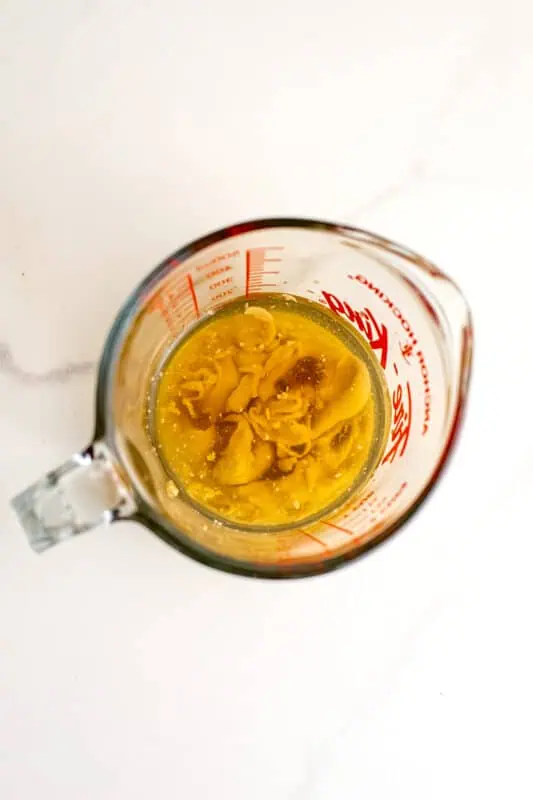 Ingredients for maple tahini dressing in a measuring cup before combining.