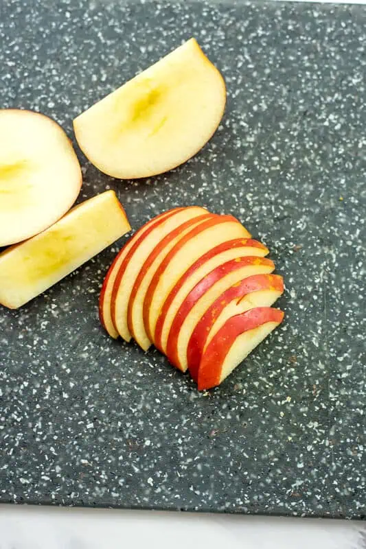 Apple slices on a grey cutting board.