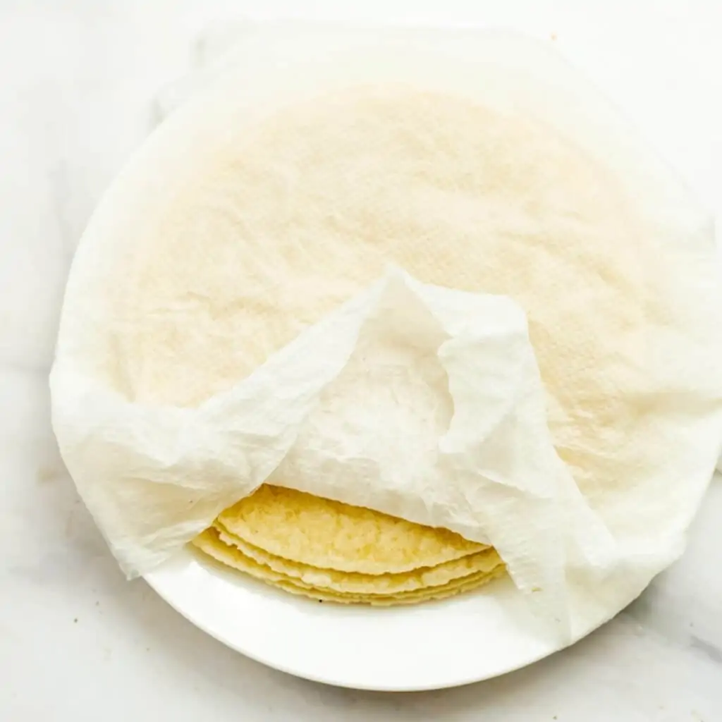 Damp paper towel over tortillas.