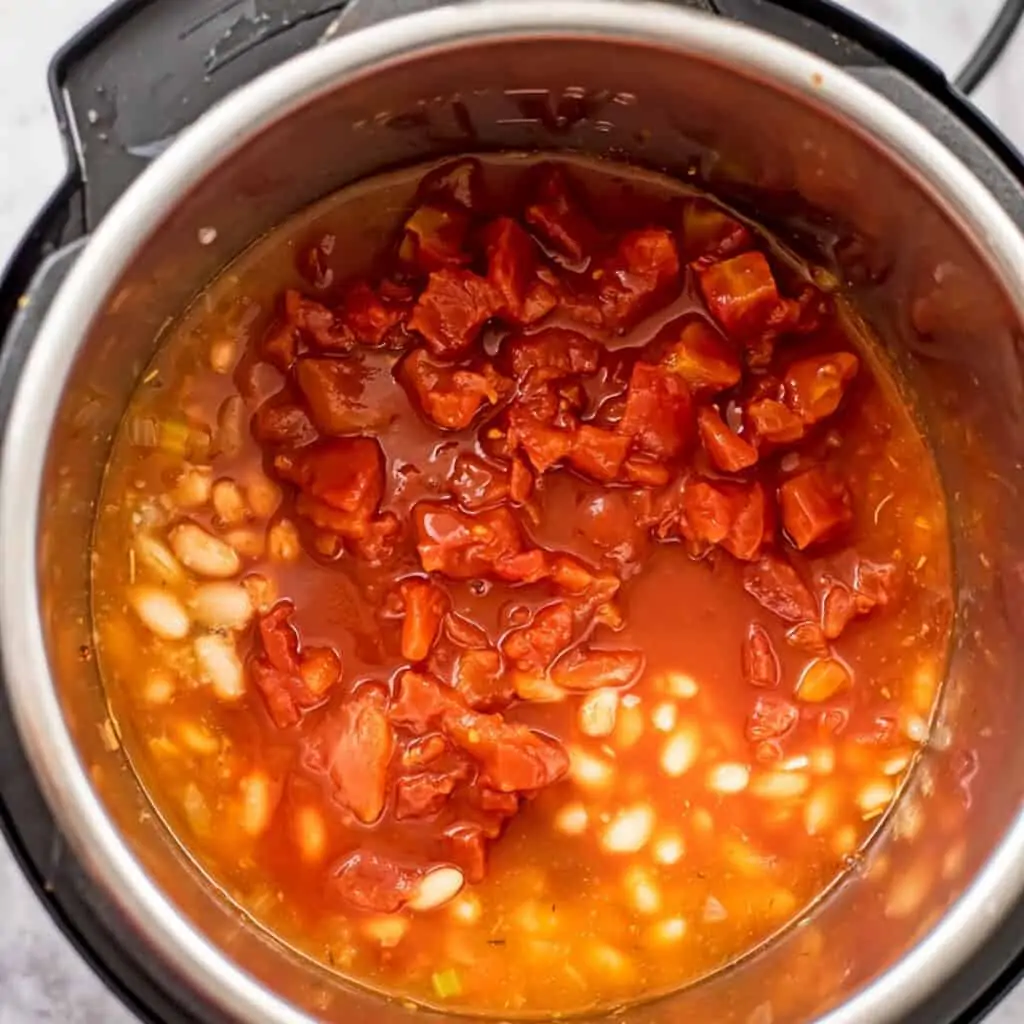 Diced tomatoes being added to the instant pot.