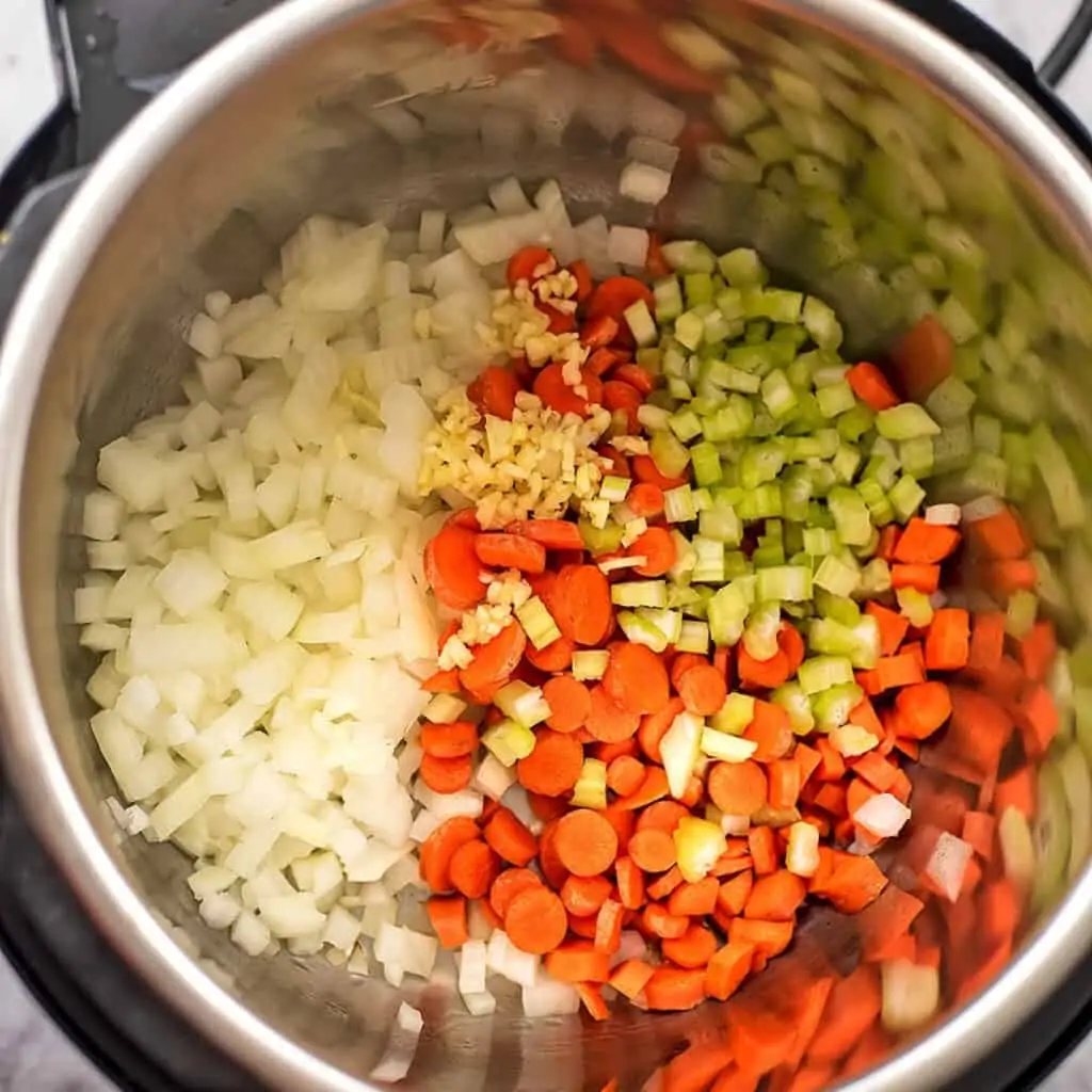 Onions, garlic, celery and carrots sauting in instant pot.