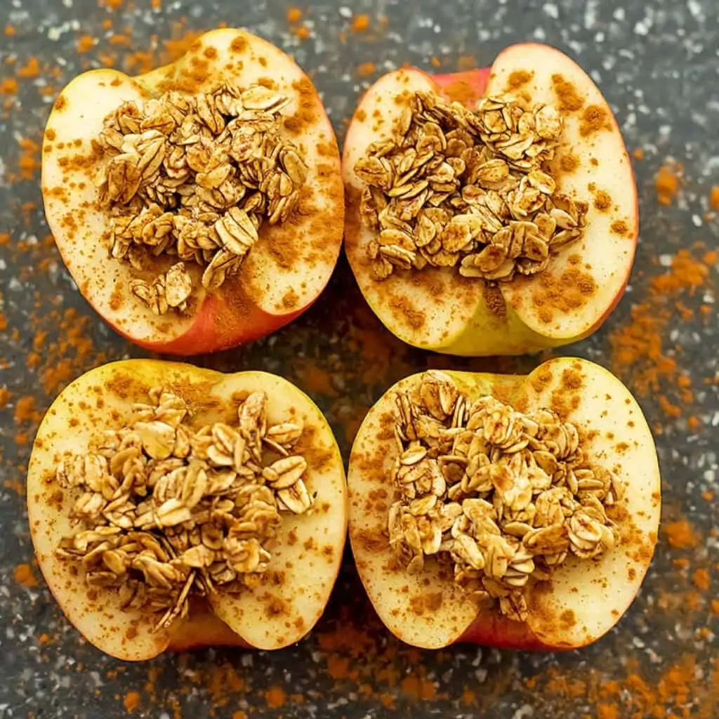 Apples with crumble topping on cutting board.