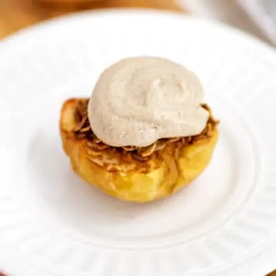Air fried apple topped iwth frosting on a white plate.