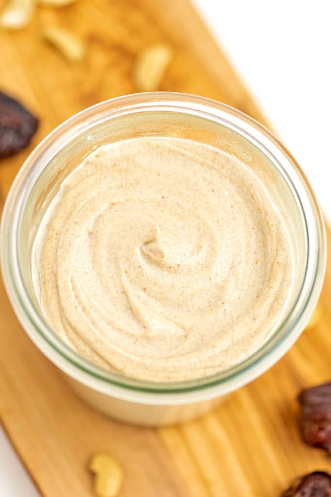 Glass jar filled with creamy cashew frosting.