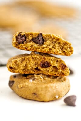 Chickpea peanut butter cookies stacked, one cut in half to show texture.