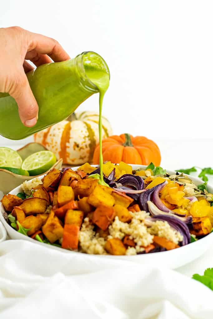Bottle of whole30 cilantro lime dressing poured over a salad.