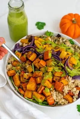Fork in bowl filled with quinoa pumpkin salad.