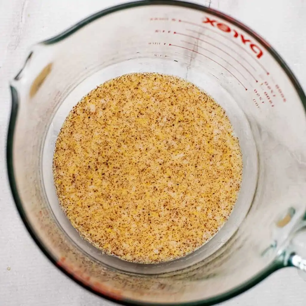 Ground flax and liquid ingredients in glass mixing bowl.