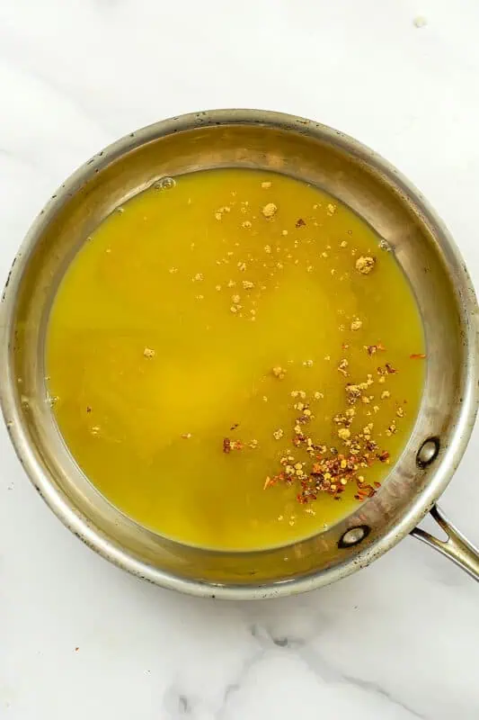 Orange sauce in a stainless steel skillet before simmering.