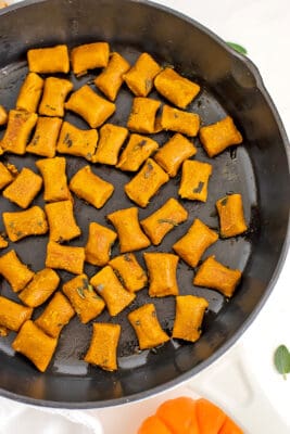 White skillet filled with vegan pumpkin gnocchi.
