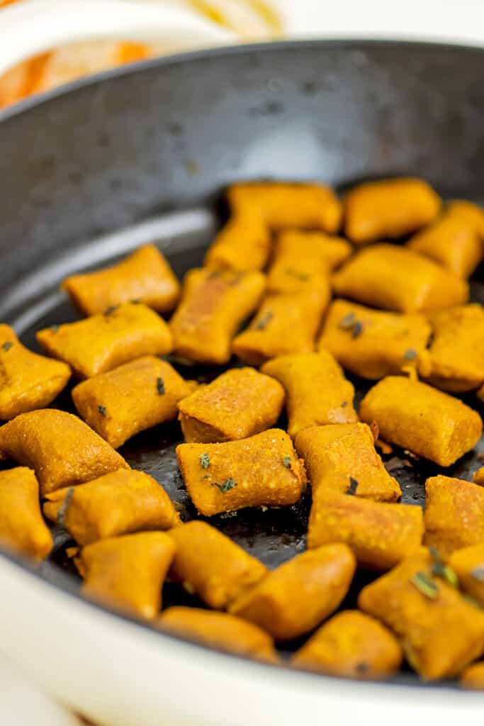 Crispy vegan pumpkin gnocchi in skillet after cookng.