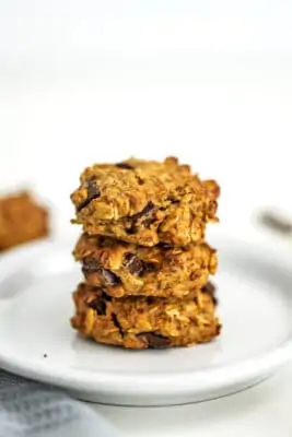 Vegan chocolate chip oatmeal cookies stacked on a plate.