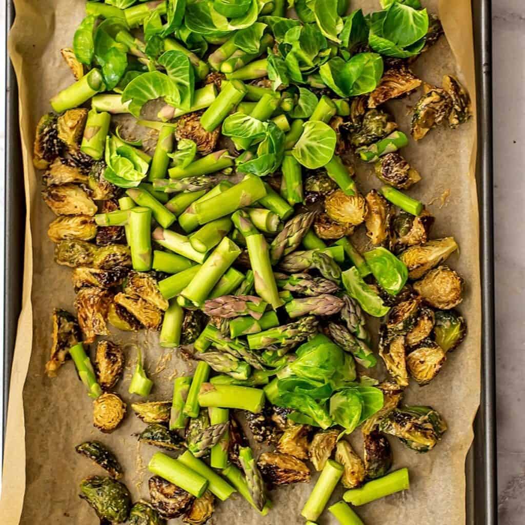 Brussel sprouts leaves and fresh asparagus over roasted brussels.