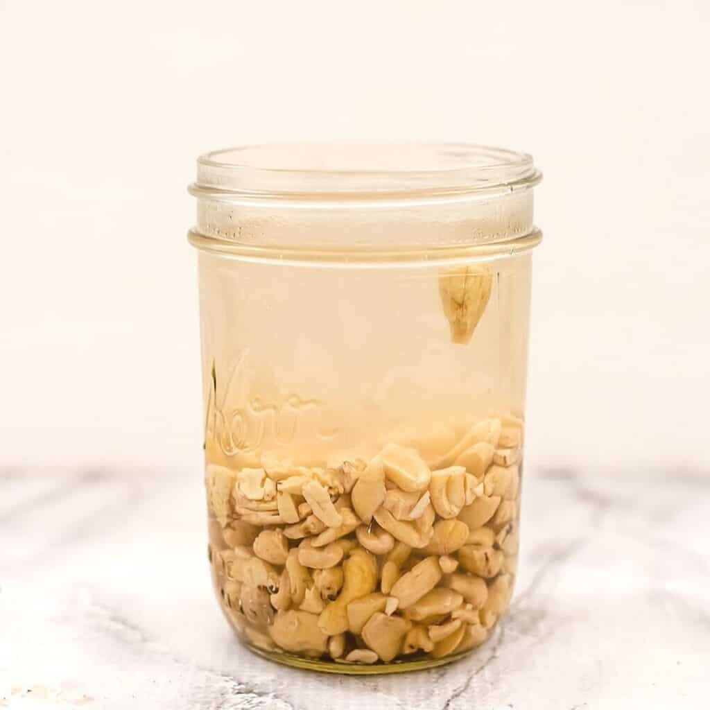 Cashews soaking in glass jar.