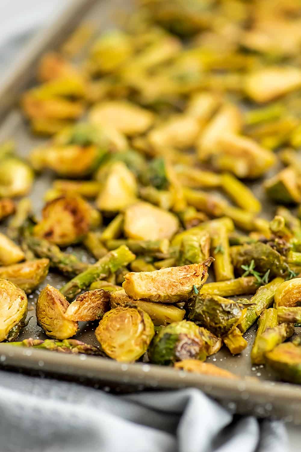 Asparagus and brussel sprouts roasted on baking sheet. 