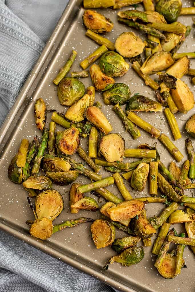 Baking sheet filled with roasted brussel sprouts and asparagus.