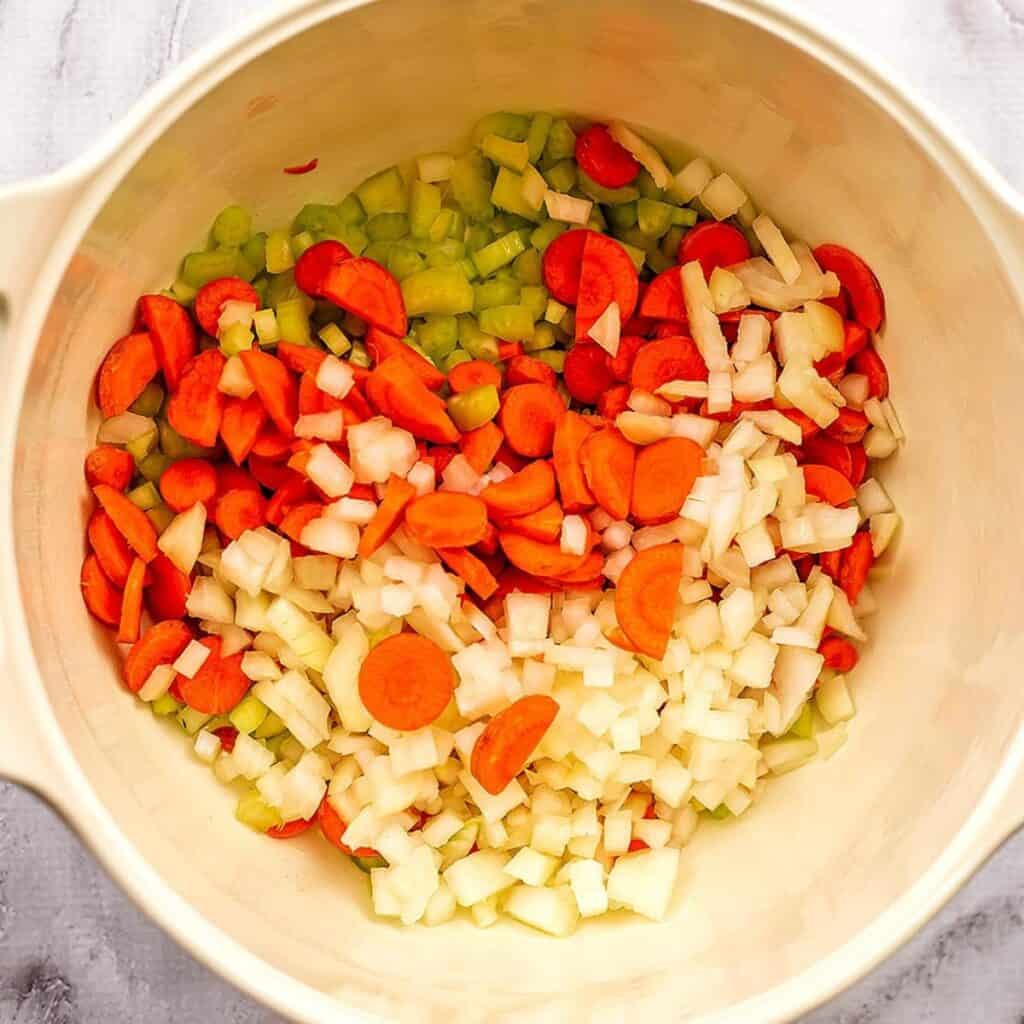 Veggies in a white pot before cooking.