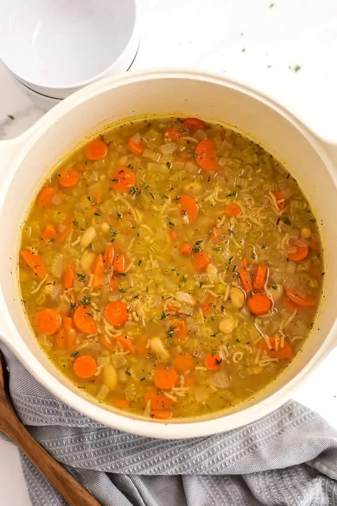 Vegan rice soup in a large white pot.