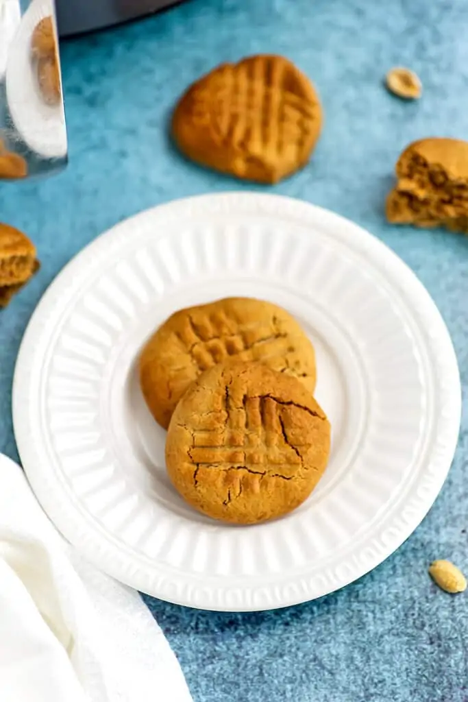 Peanut butter cookies on white plate with cross hatch marks.