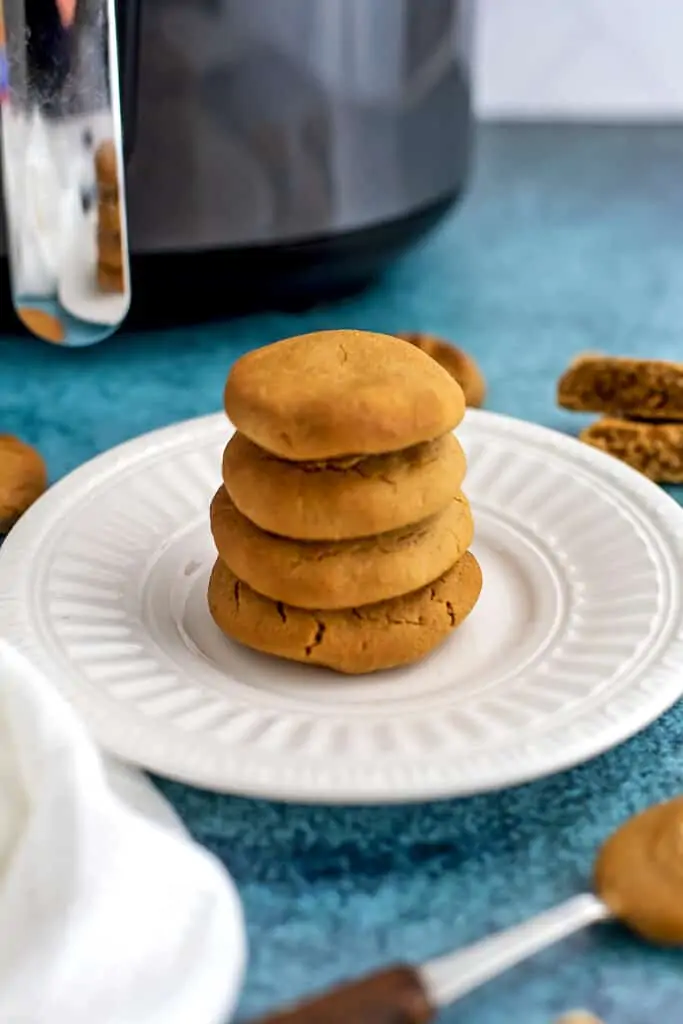 Peanut butter cookies on a white plate stacked 4 high.