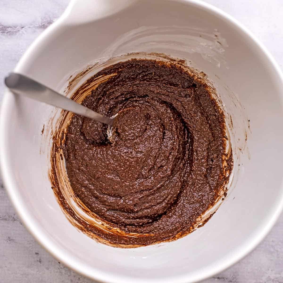 Chocolate cookie dough in a white bowl.