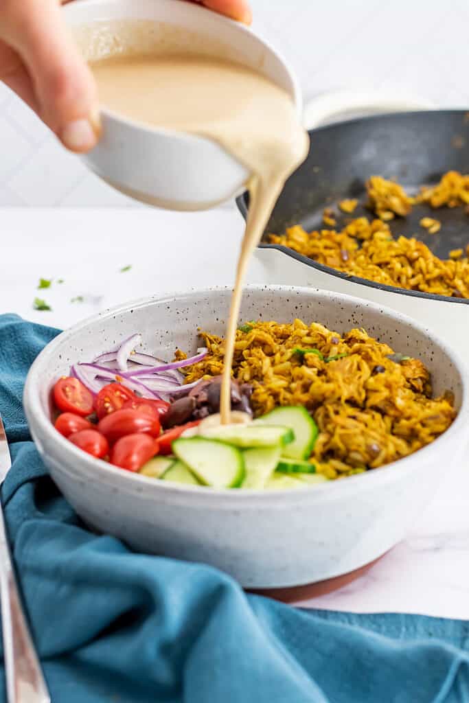 Tahini lime dressing poured over a grain bowl.