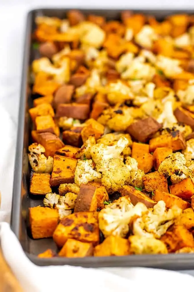 Roasted sweet potatoes and cauliflower on sheet pan after baking.