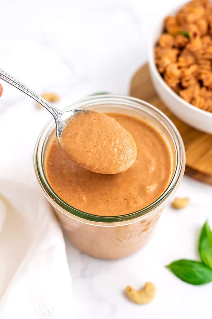 Glass jar filled with creamy tomato pasta sauce.