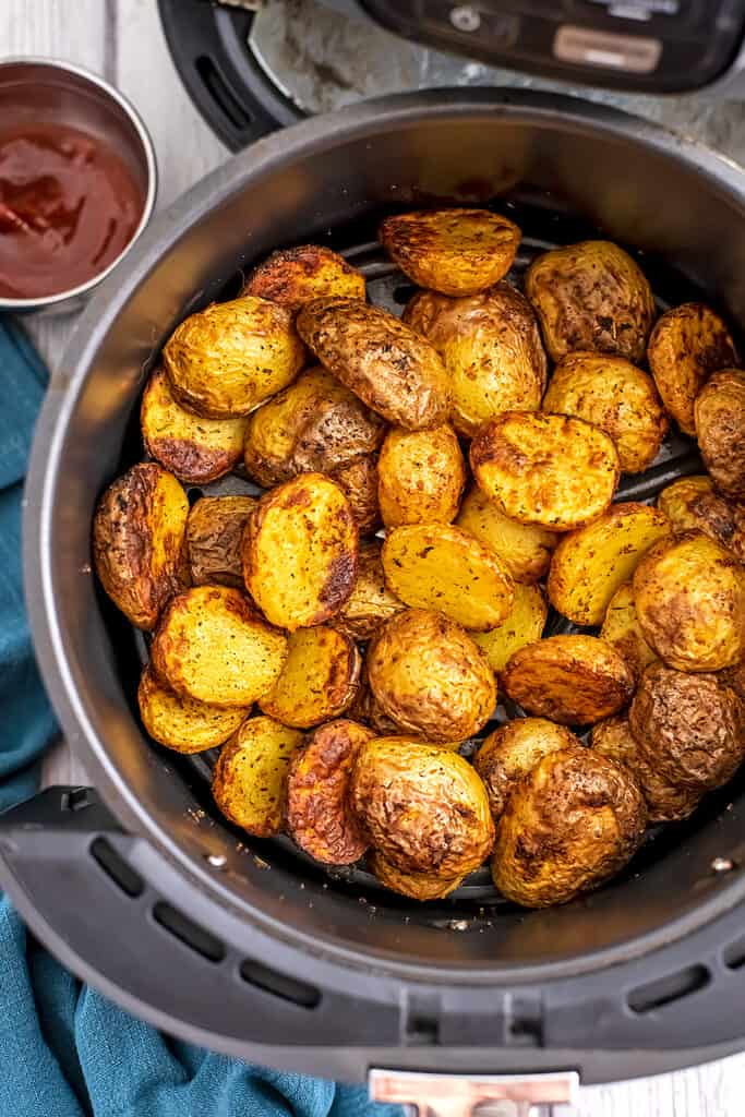 Small potatoes in air fryer basket.