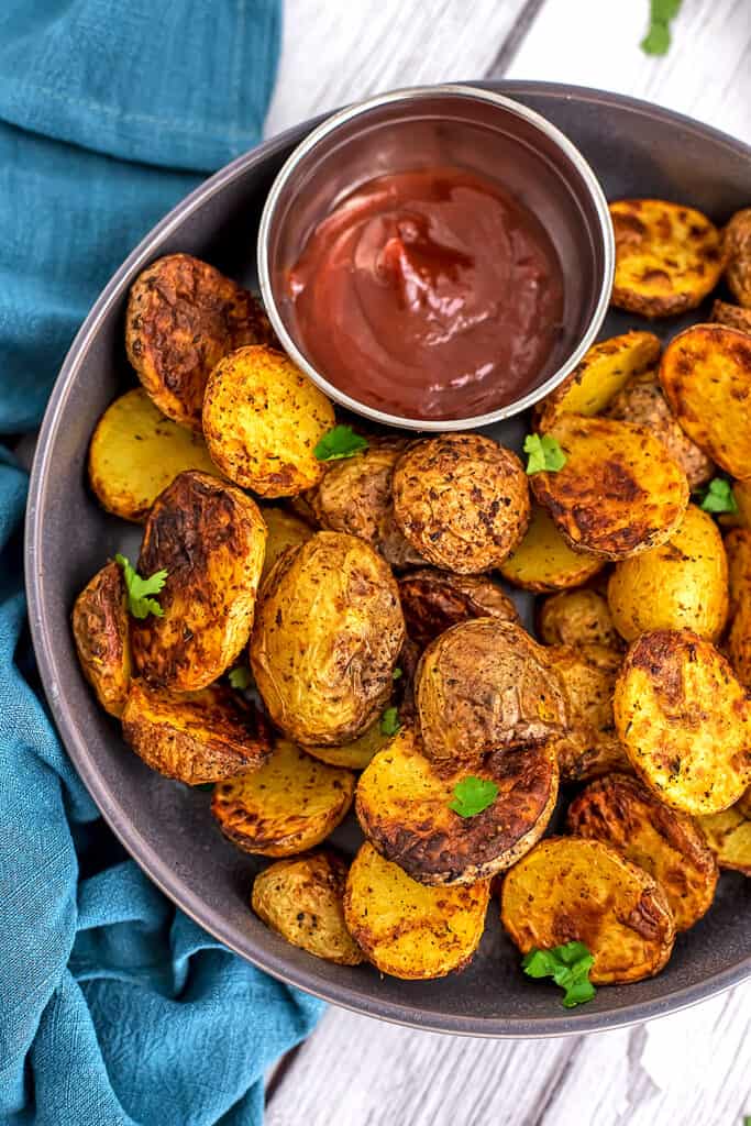 Baby potatoes cooked in air fryer on grey plate.