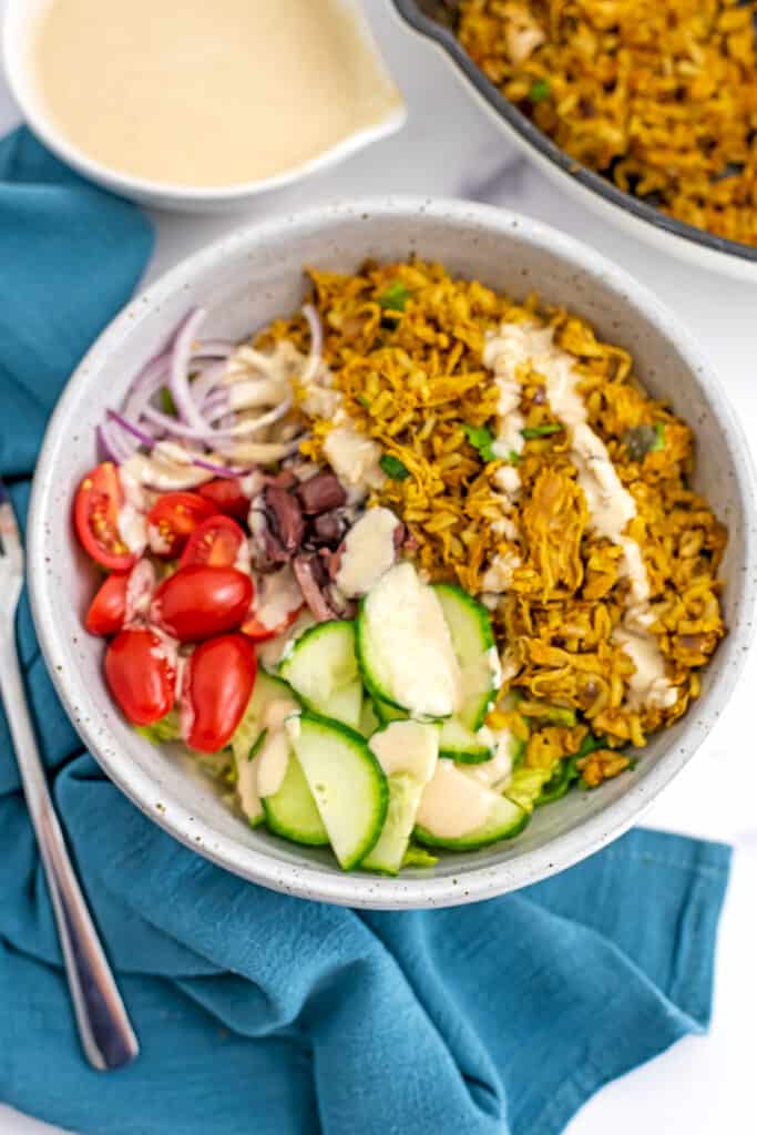 Bowl filled with chicken shawarma rice and fresh veggies.