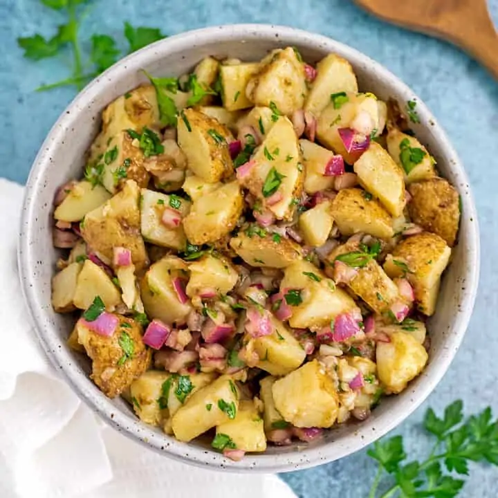 Moroccan potato salad in a bowl with white napkin on the side.