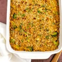 Vegan broccoli rice casserole with white napkin and wooden spoon.