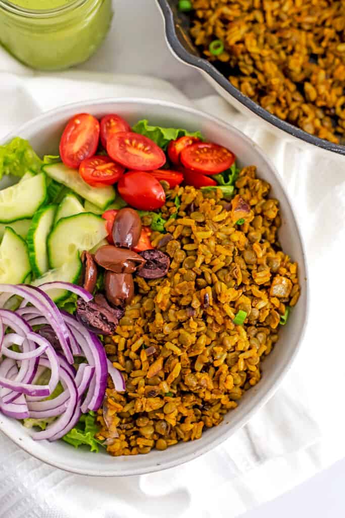 Lentil and rice vegan shawarma with chopped veggies in a white bowl. 