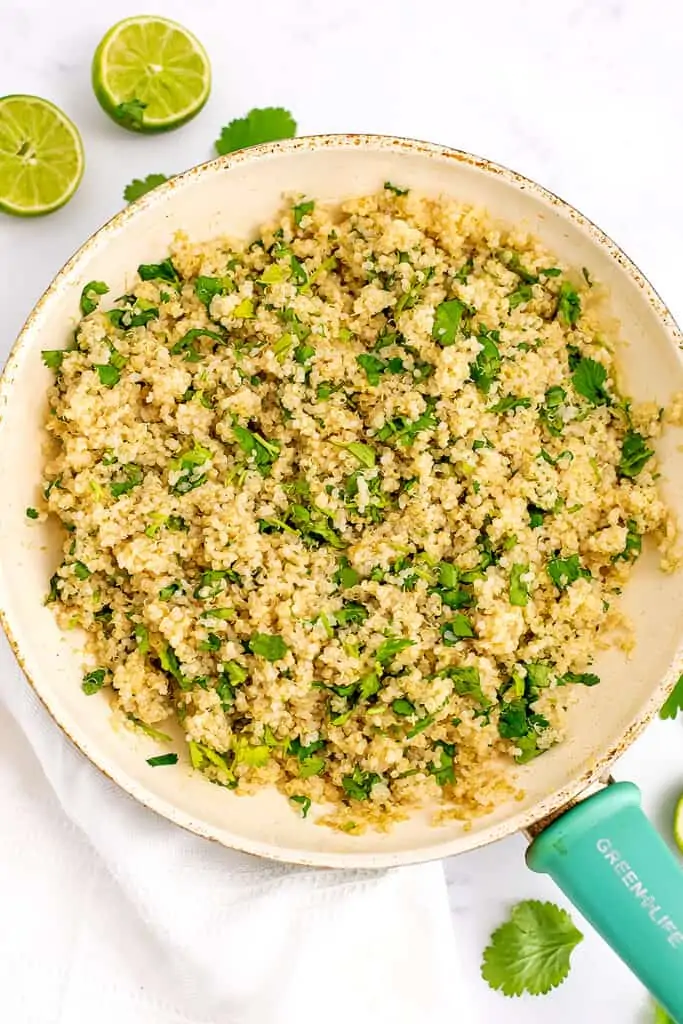 Cilantro lime rice in a white skillet with a green handle.
