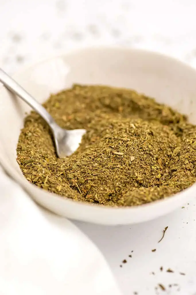 Spoon in a bowl filled with homemade Italian seasoning.