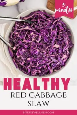 Tongs resting in a bowl of red cabbage slaw