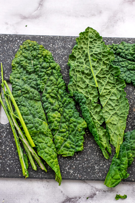 Kale on cutting board with center removed.