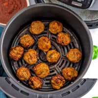 Air fryer basket with chicken meatballs after cooking.