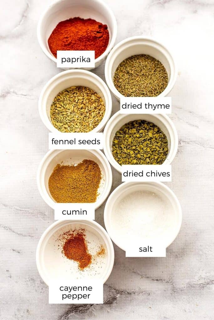Ingredients to make cajun seasoning in white ramekins.